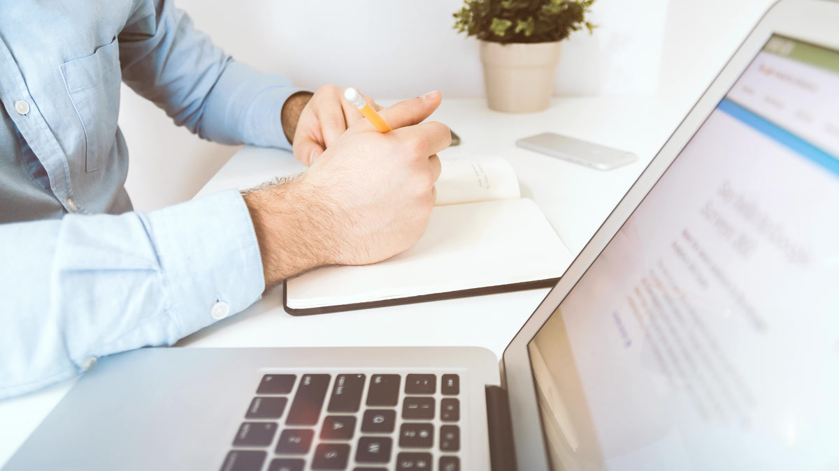 Professional using AI safely at work with a laptop and business notes